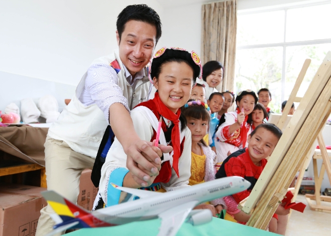 아시아나항공은 14일 중국 윈난성 리장시 위룽나시족자치현 롱판촌에 소재한 롱판씨앙씽밍 소학교에서 '희망소학교 준공식'을 가졌다. 아시아나항공 직원 봉사단과 롱판씨앙씽밍 소학교 학생들이 미술 수업을 진행하고 있다. 사진=아시아나항공