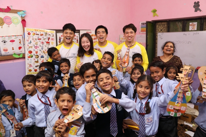 인도 뉴델리 '마하비르 엔클라브'마을에서 아시아나항공 임직원 봉사단이 학생들과 '만들기 교실'을 마치고 기념사진을 찍고 있다. 사진=아시아나항공