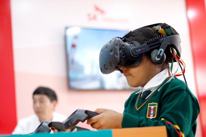 페루 현지 어린이가 이동형 ICT 체험관 ‘티움(T.um)에서 모바일 가상현실(VR)을 체험하고 있는 모습.