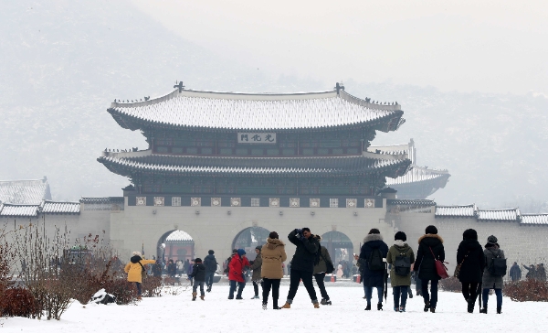 약하게 눈과 비가 내리는 10일 오전 서울 종로구 광화문광장에서 외국인 관광객들이 사진을 찍으며 즐거운 시간을 보내고 있다,/뉴시스
