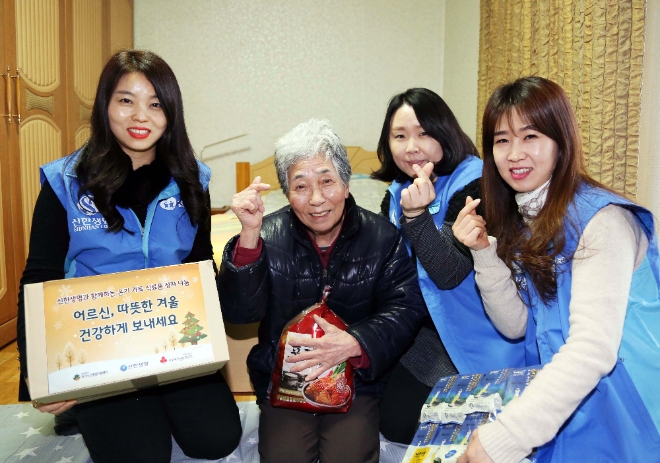 자원봉사자들이 서울 강북구 소재 홀몸노인 가정에 방문해 식료품을 담은 바구니를 전달했다. 신한생명=제공
