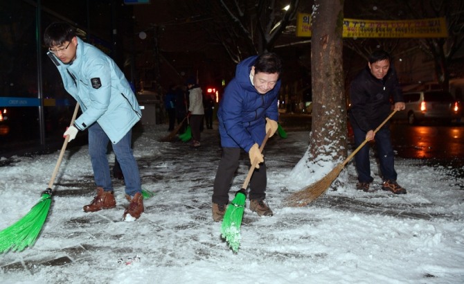 윤장현 광주광역시장이 대설주의보가 발효된 10일 새벽 동구 학운동 주민센터 인근 도로에서 비상근무 발령에 따라 제설작업에 투입된 공무원들과 인도에 쌓인 눈을 쓸고 있다./광주광역시=제공