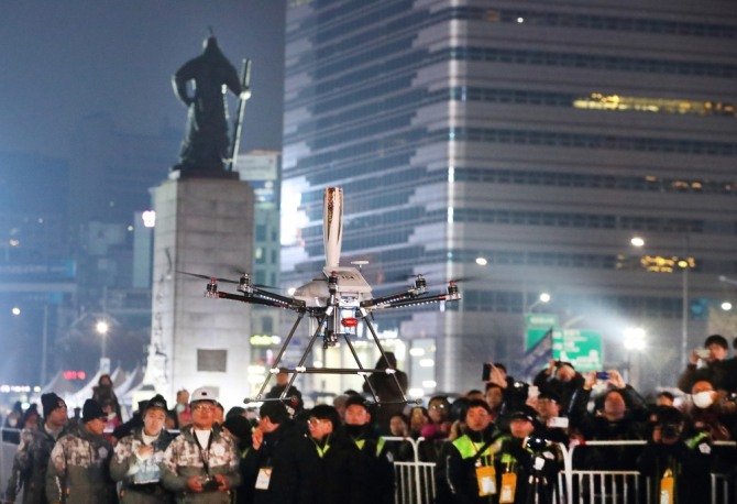 지난 13일 서울 종로구 광화문광장에서 5G 네트워크를 연결한 5G 드론이 성화봉송 퍼포먼스를 진행하고 있다.