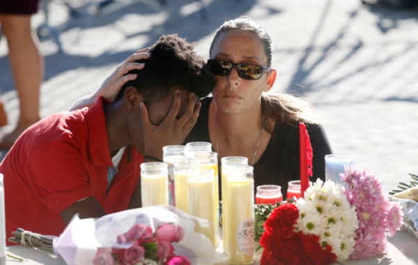 한 학생이 플로리다 총기난사사건 희생자 추모식에 참석해 참담한 심경에 손으로 얼굴을 가리고 있다. 사진=뉴시스