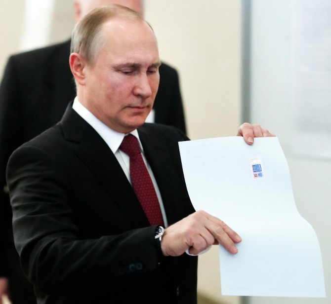 블라디미르 푸틴 러시아 대통령이 18일(현지시간) 모스크바에서 대통령 선거 투표용지를 투표함에 넣고 있다. 푸틴 대통령은 출구조사에서 73% 이상의 압도적 득표율로 6년 임기의 4기 도전에 성공했다. 사진=뉴시스