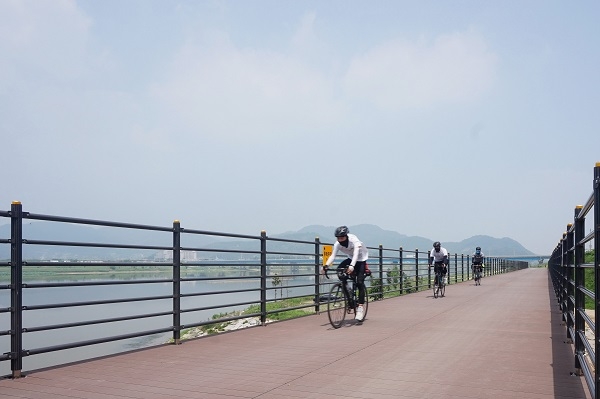SK케미칼의 에코젠이 적용된 목재 플라스틱 복합재 자전거가 도로 위를 달리고 있다. 사진=SK케미칼. 