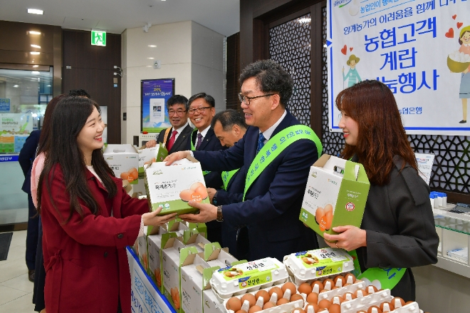 12일 서울시 중구 농협은행 본점 1층 영업부에서 이대훈 농협은행장이 고객에게 계란을 나눠주고 있다
