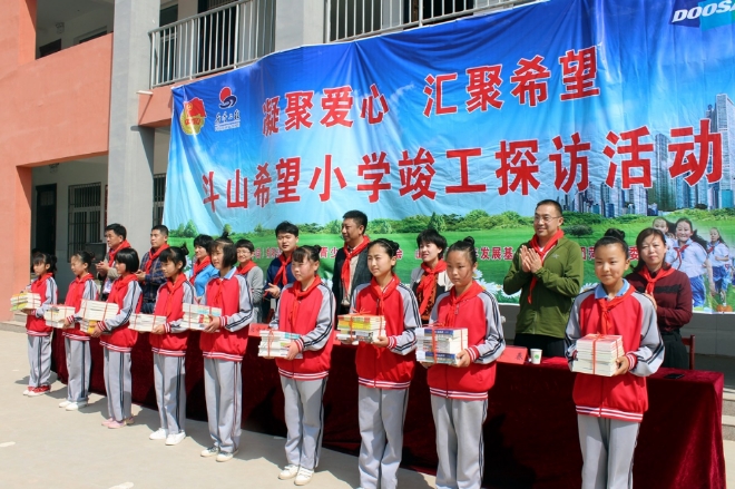 두산인프라코어가 최근 중국 산둥성 허쩌시에서 두산희망소학교 준공식을 열고 학생들에게 도서와 체육용품을 전달했다. 사진=두산인프라코어