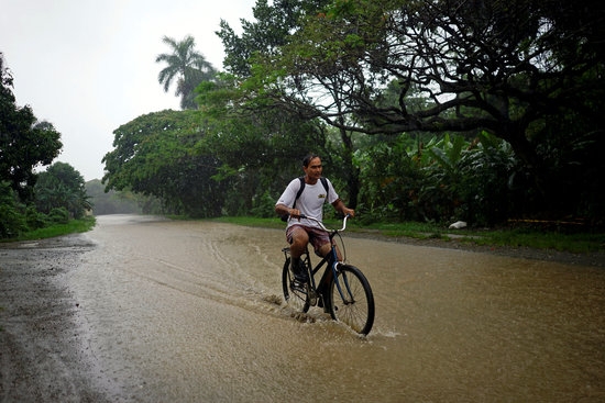 한 남성이 열대성 폭풍 '알베르토'로 인해 물에 잠긴 도로 위를 자전거를 타고 가고 있다. 사진=로이터/뉴스1