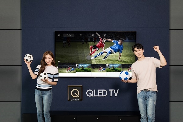 삼성전자 모델들이 2018년형 QLED TV의 AI기반 축구 큐레이션 서비스를 통해 축구 경기를 시청하고 있다. 사진=삼성전자. 