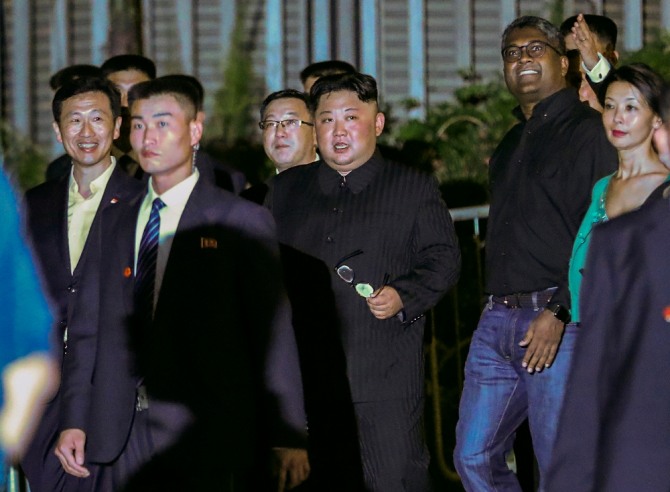  김정은 북한 국무위원장이 11일 싱가포르 정부 관계자 및 경호들과 함께 마리나 베이를 산책하고 있다. 뉴시스