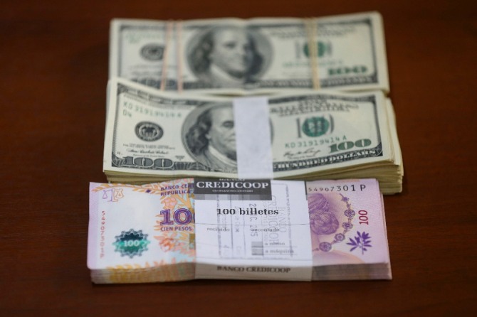 아르헨티나 부에노스아이레스의 한 환전소 책상에 놓여있는 달러화와 페소화 지폐다발. 중앙은행 총재 교체라는 극약 처방에도 불구하고 페소화의 가치는 사상 최저치로 추락했다. 사진=뉴시스