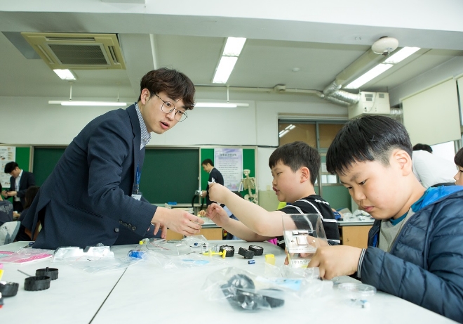 서울 개원초등학교 학생들이 주니어 공학교실에서 현대모비스 직원 강사들의 도움을 받아 태양광 자동차를 만들고 작동해보고 있다. 사진=현대모비스 