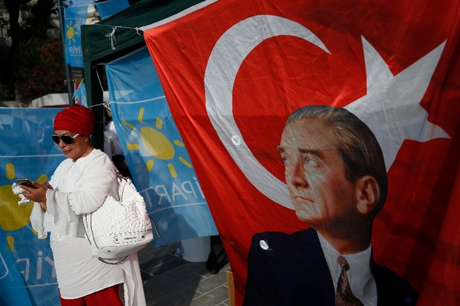 6월 24일 대선과 총선을 앞두고 한 여성이 대형 깃발 옆에서 스마트폰을 만지고 있다. 터키는 이번 선거를 계기로 의원내각제에서 대통령중심제로 정부 통치 형태가 바뀌게 된다. 사진=AP/뉴시스