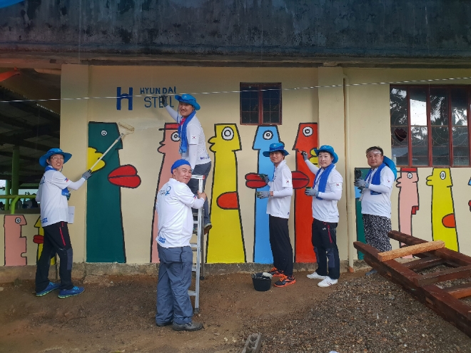 현대제철 글로벌 임직원 봉사단원들이 로페드베가 초등학교 건물벽에 귀엽고 깜찍한 그림을 더해 초등학교 분위기를 한껏 살리고 있다. 사진=현대제철 