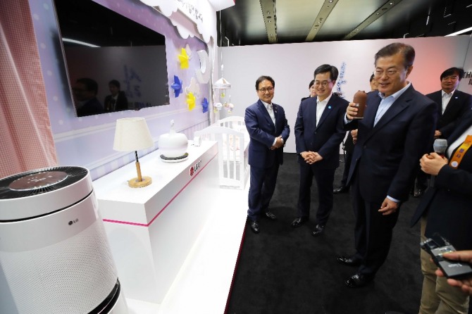 문재인 대통령이 지난 5월 17일 서울 강서구 마곡 R&D 단지에서 열린 혁신성장 보고대회에서 LG유플러스 관계자로부터 인공지능(AI)을 이용한 제품을 살펴보고 있다. 사진=뉴시스