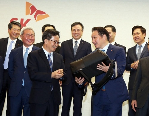 지난 3월, SK그룹을 방문한 김동연(왼쪽) 경제부총리 겸 기획재정부 장관이 최태원 회장으로부터 구매한 컨티뉴 가방을 전달 받고 있다. 사진=SK이노베이션. 