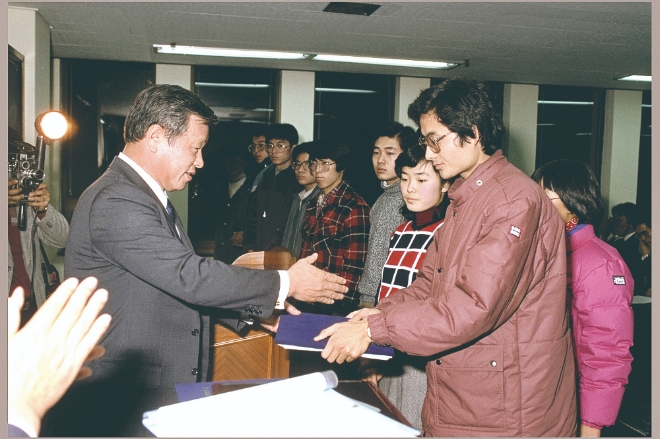 故 최종현 회장이 1986년 해외 유학을 앞둔 한국고등교육재단 장학생들에게 장학증서를 전달하고 있다.  사진=SK