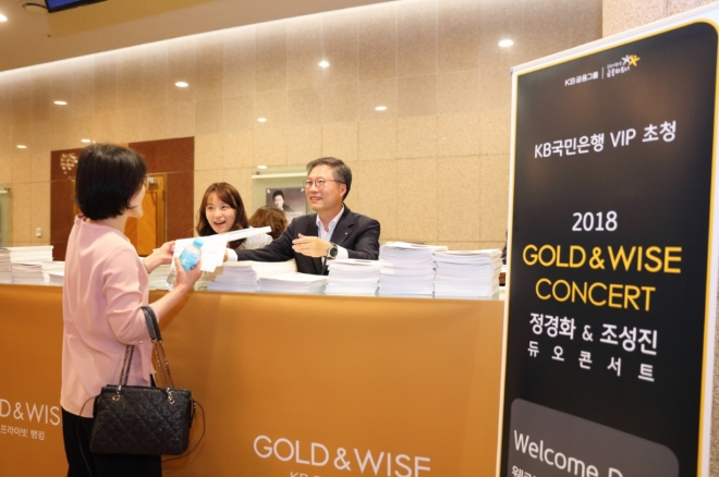 지난 11일 서울 예술의전당 콘서트 홀에서 열린 'GOLD&WISE CONCERT: 정경화 & 조성진 듀오 콘서트' 에서 (오른쪽 첫번째)김영길 KB국민은행 IPS본부장이 관객에게 기념품을 전달하고 있다.