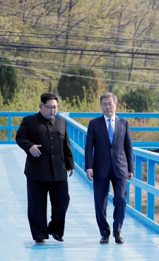문재인 대통령과 김정은 국무위원장이 군사분계선 표식물이 있는‘도보다리’를 산책하며 담소를 나누고 있다=청와대 제공