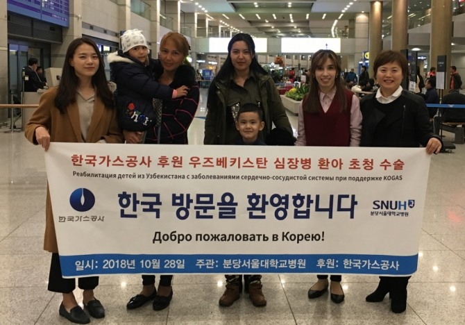지난 28일 인천국제공항에 입국한 우즈베키스탄 심장병 환아 가족들과 가스공사 상생협력부 직원들이 기념사진을 찍고 있다.사진=한국가스공사. 