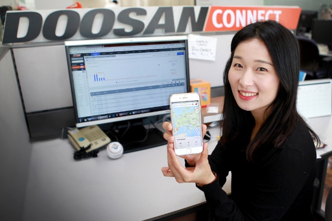 두산인프라코어가 출시한 두산커넥트 모바일 앱 화면을 담당 직원이 보여주고 있다. 사진=두산인프라코어