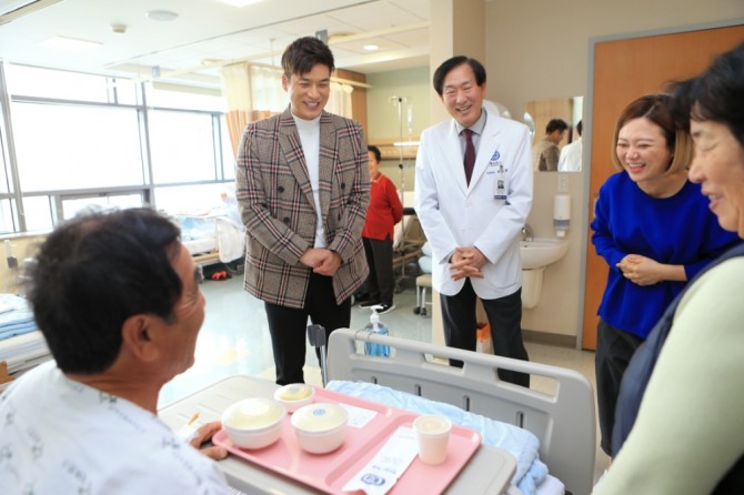 윤도흠 연세의료원장이 개그맨 송병철·김숙과 함께 점심 시간 배식에 참여해 환자와 인사를 나누고 있다(사진=연세의료원)