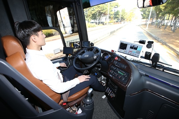 KT 자율주행 버스를 탑승한 KT 직원이 양손을 놓고 차량으로 전달되는 신호를 확인하고 있다. (사진=KT)