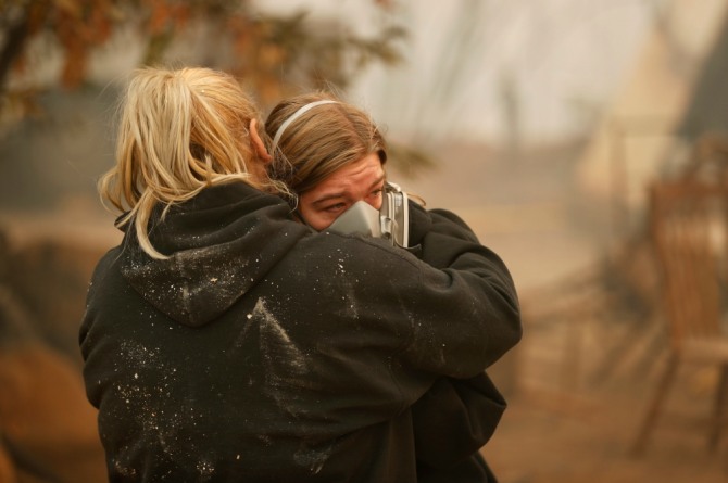미 캘리포니아주 패러다이스에서 10일(현지 시간) 한 모녀가 산불로 불타 없어진 자신들의 옛 집 앞에서 슬픔에 잠겨 있다. 이번 캘리포니아주 산불로 인해 수십 명이 사망하고 수천 채의 주택이 불타 전소됐다. 사진=AP/뉴시스