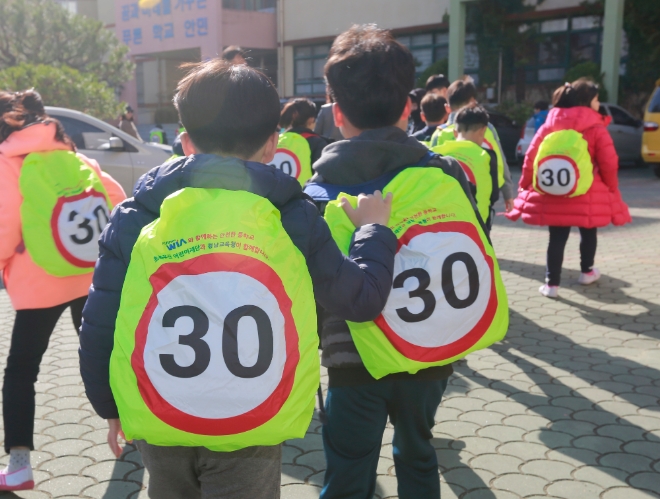 지난 20일 경남 창원시 성산구 안민초등학교에서 학생들이 현대위아가 기증한 어린이용 안전 가방 덮개를 씌운 가방을 메고 하교하고 있다. 현대위아는 내년 1학기 개학 전까지 전국 사업장 인근 초등학교에 2만여개의 안전 가방 덮개를 배포할 계획이다. 사진=현대위아 