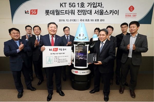 이필재 KT 마케팅부문장 부사장이 인공지능 로봇 ‘로타’의 5G 머신 1호 가입자 증서를 박동기 롯데월드 대표에게 전하고 있다.(사진=KT)
