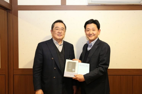 구자열 LS그룹 회장이 14일, LS용산타워에서 신규 임원이된 LS산전 박석원 이사에게 책을 선물하고 있다. 사진=LS.