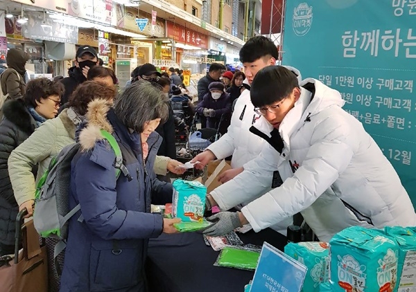 KT가 15일 서울 마포구 망원시장에서 소상공인 지원 온(ON)마켓 행사를 진행하며, 시장 방문 고객들에게 장바구니와 온쫄면, 온음료 등을 나눠주고 있다. (사진=KT)