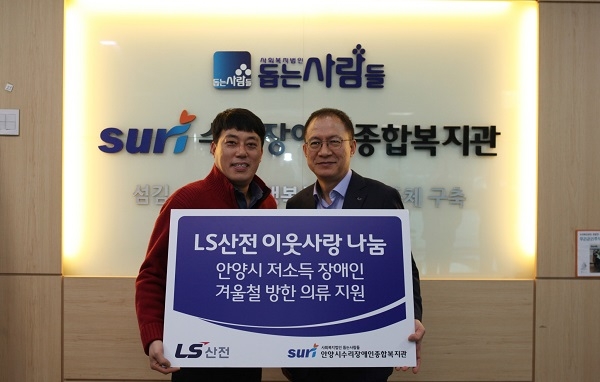 김유종 LS산전 이사(오른쪽)이 20일 경기도 안양시 만안구 소재 안양시수리장애인종합복지관에서 유정환 관장에게 방한복을 전달한 뒤 기념촬영을 하고 있다. 사진=LS산전.