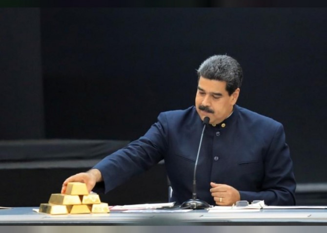 2018년 3월 22일 베네수엘라 카라카스의 미라프로레스 궁전에서 마두로 대통령이 경제 분야 책임자들과 만난 자리에서 금 바(Bar)를 만지고 있다. 자료=로이터/뉴스1