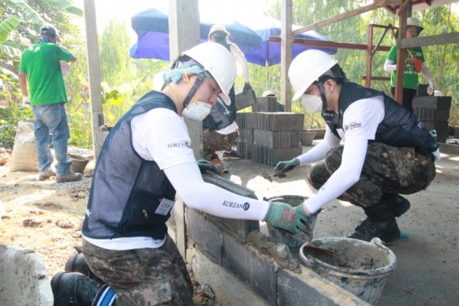 '코리안리 신입사원 해외봉사단'이 태국 아유타야에서 외벽 쌓기 작업을 하고 있다./사진=코리안리재보험