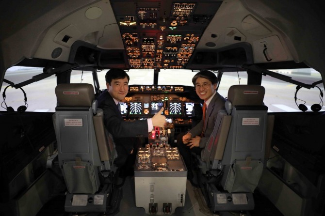 지난 19일 진행된 시뮬레이터 도입행사에서 이석주 제주항공 사장(왼쪽)과 김재천 부사장이 시뮬레이터 안에서 기념촬영을 하고 있다. 사진=제주항공