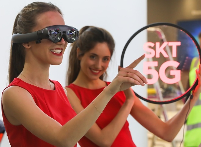 SK텔레콤 모델이 차세대 AR 글래스를 착용하고 5G 기술을 이용한 AR,VR 솔루션인 T 리얼을 체험하고 있다.(사진=SK텔레콤)
