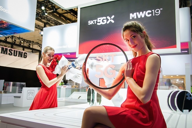SK텔레콤 모델이 전시관 내 5G 커넥티드 팩토리 솔루션의 로봇이 전해주는 꽃다발을 건네받고 있다.(사진=SK텔레콤)