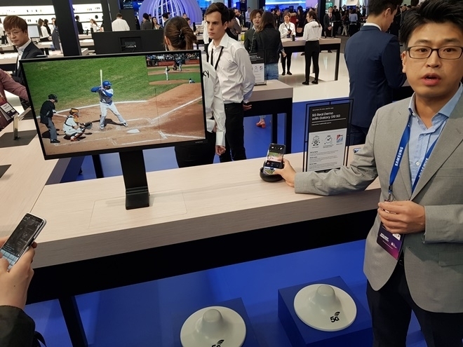 MWC19 메인 행사장에서 삼성전자 관계자가 5G폰을 이용해 속도지연 없이 야구선수의 위치와 공이 날아간 방향을 단말기 상에서 손가락으로 조종해 가며 실시간으로 확인할 수 있다는 것을 보여주고 있다.(사진=이재구기자)