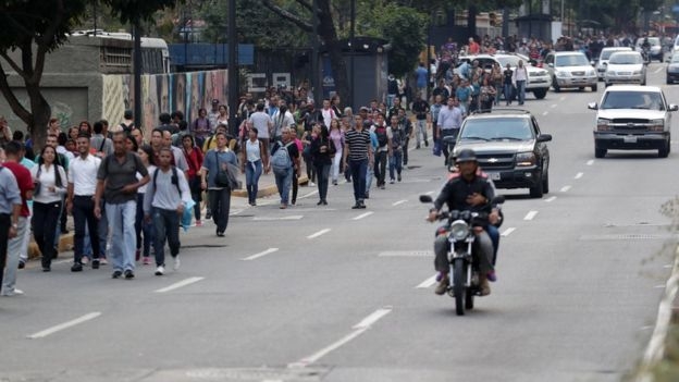 대규모 정전이 발생한 베네수엘라 수도 카라카스에서 직장과 학교가 폐소되자 시민들이 걸어서 퇴근하고 있다. 사진=BBC