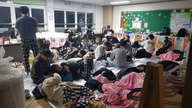 아야진 초등학교로 급히 피신해 휴대폰으로 산불 상황을 지켜보는 경동대 기숙사생들. 사진=경동대 이만식 교수