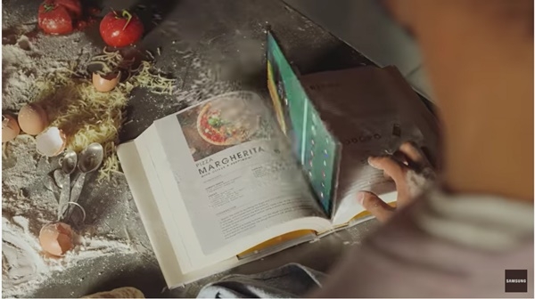 삼성전자는 TV광고에서 윗층에서 떨어뜨린 갤럭시S5e가 요리책 사이에 끼워질 정도로 얇다는 것을 강조한다. (사진=삼성전자)