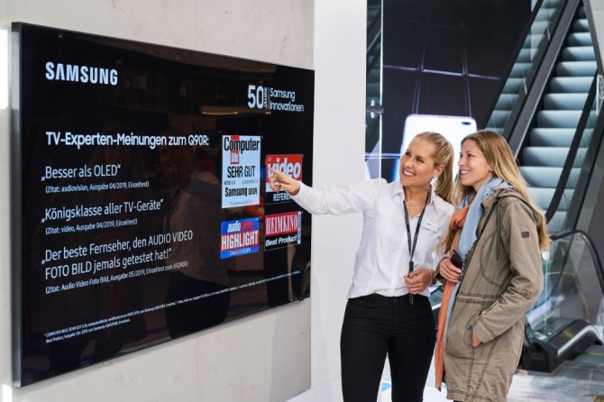 독일 프랑크푸르트 시내에 위치한 삼성 쇼케이스 매장에서 판매 직원이 고객에게 영상·음향기기 전문 매체들로부터 호평받은 2019년형 QLED TV를 소개하고 있다. (사진=삼성전자 제공) 