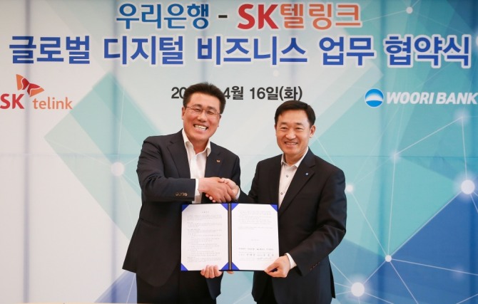 SK텔링크 김선중 대표이사(왼쪽)와 정채봉 우리은행 영업부문장이 4월 16일 우리은행 본점에서 '글로벌 디지털 비즈니스 협력 MOU'를 체결했다. 사진=우리은행
