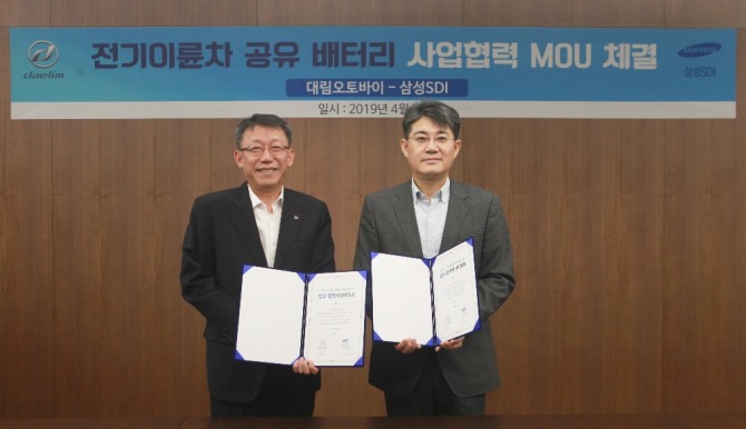 대림오토바이 배원복 대표이사(왼쪽)와 삼성SDI 전략마케팅실 김정욱 부사장(오른쪽)이 전기이륜차 공유 배터리 사업협력 MOU를 체결하고 기념사진을 찍고 있다. 사진=대림산업