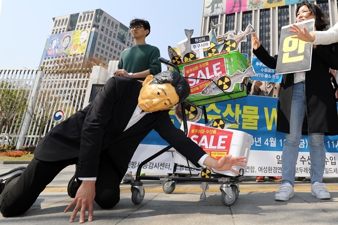 일본산 수산물 수입 대응 시민 네트워크가 4월 12일 오전 서울 종로구 정부서울청사 앞에서 일본산 수산물 WTO 분쟁 승소 관련 기자회견을 열고 아베 신조 일본 총리가 좌절하는 퍼포먼스를 펼치고 있다.    사진=뉴시스