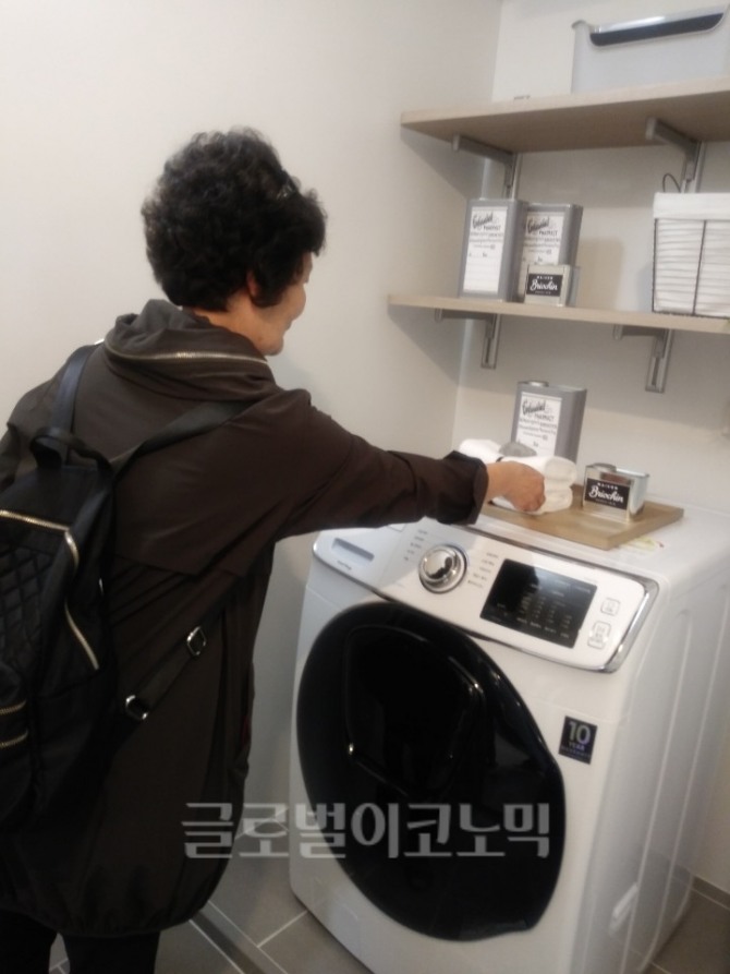 세탁기 위에 건조대 설치할 공간이 부족해 보인다고 아쉬움을 나타낸 여성 방문자의 모습 사진=오은서 기자