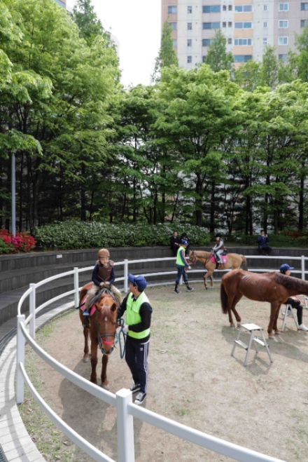 지난 4월 27일 서울 왕십리광장에서 열린 한국마사회 '도심승마체험' 프로그램에 참가한 어린이가 진행요원의 도움을 받고 말타기를 즐기고 있다. 사진=한국마사회 