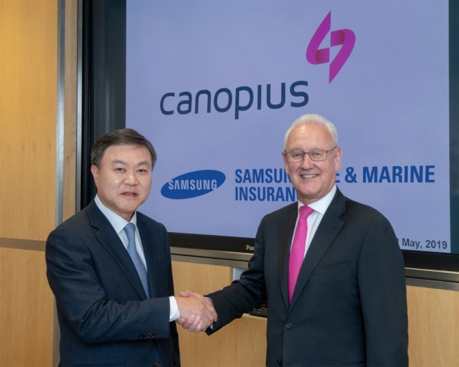 최영무 삼성화재 사장(왼쪽)과 마이클 왓슨 캐노피우스 회장이 영국 런던 캐노피우스 본사에서 전략적 파트너십 계약 체결 후 악수를 하고 있다./사진=삼성화재
